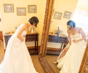 Bride in front of a large mirror checks her dress