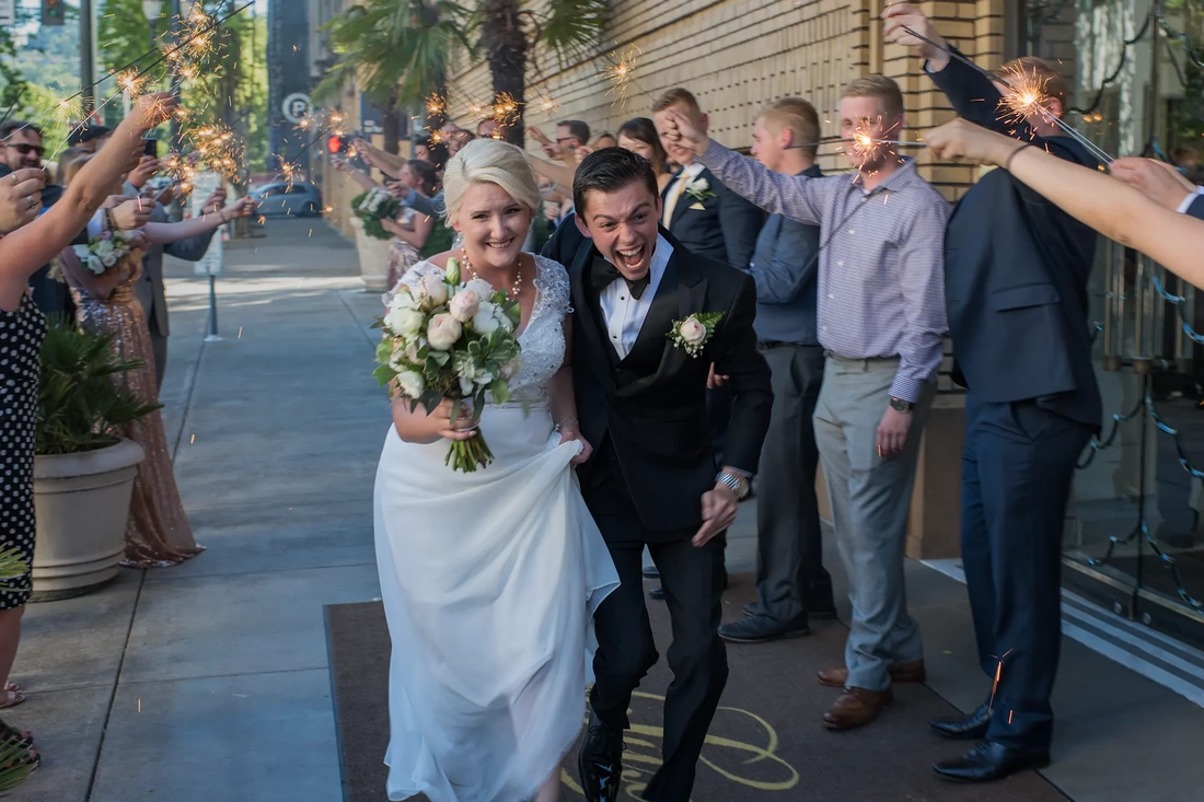Hotel Deluxe Wedding in Portland Oregon by Photographer Robert Knapp bride and groom run through sparklers