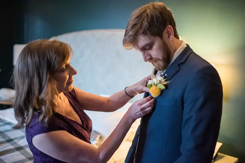 mother of the groom pins a flower on the grooms lapel ​Modern Art Photograph 
Wedding Photographers in Portland
on location at the 
Portland Sentinel Hotel