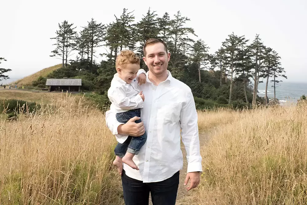 a father and child laugh in the fall grass Oregon Coast Engagement Photos 
With 
Modern Art Photograph