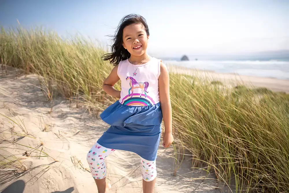 little girl smiles and has the sun at her back, in the distance the ocean Portland ​Family Photographer Robert Knapp - Book Today! ​Family Photographer Robert Knapp in Portland - Book Today!