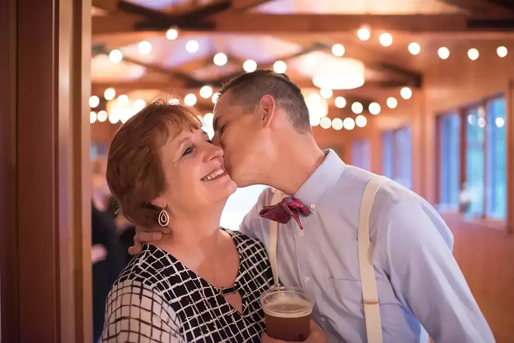 groom kisses his mother on the cheek at Silver Falls Weddings with Modern Art Photograph