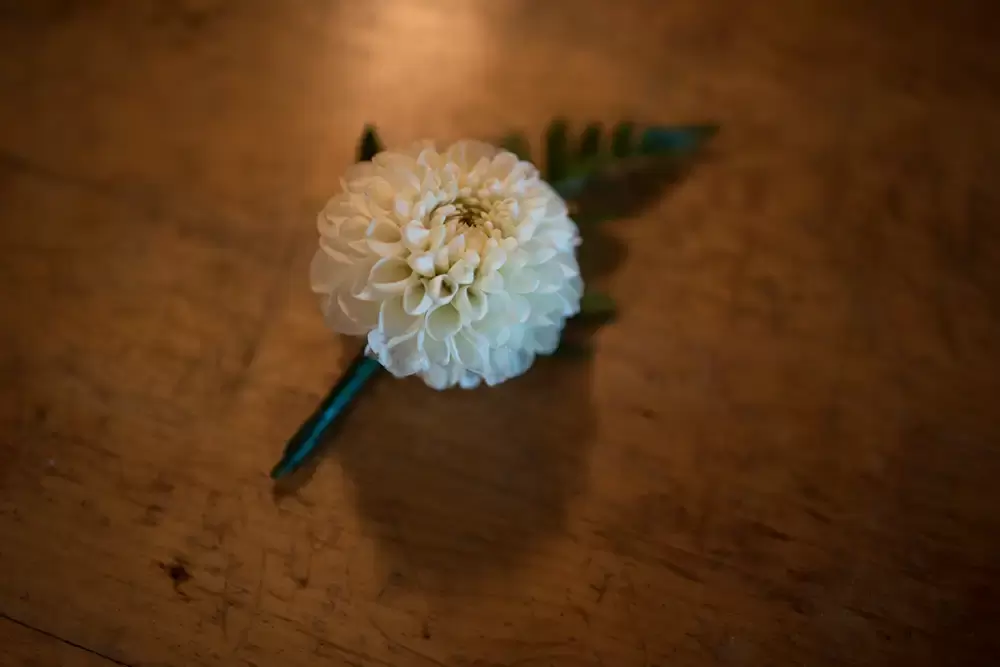 Tin Roof Weddings Barn Weddings Venues Near Me from Photographer Robert Knapp A close-up of the grooms boutonniere on a wood surface